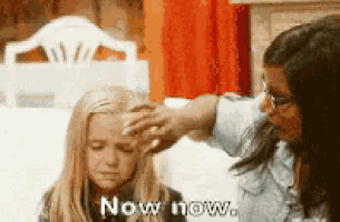a woman is touching a little girl 's forehead with the words now now written on it