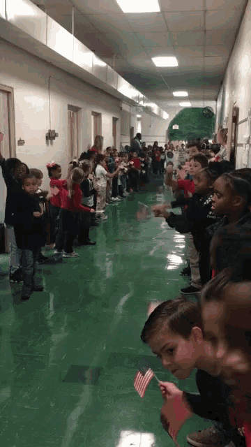 a group of children standing in a hallway holding flags