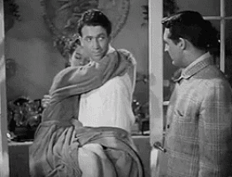 a man is holding a woman in his arms while another man stands behind them .