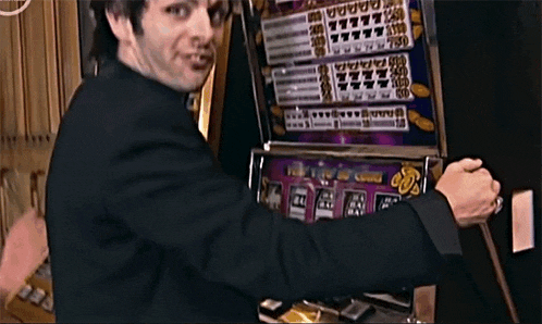 a man in a suit is playing a slot machine that has a percentage of 80 % on it