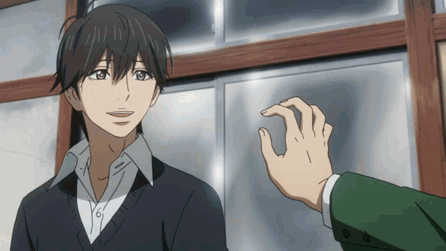 a man in a suit is smiling while another man holds his hand out towards him