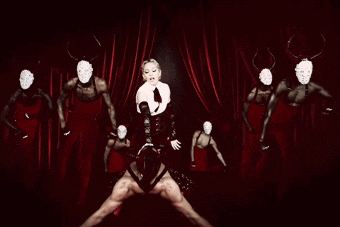 a woman in a corset is surrounded by a group of men wearing masks