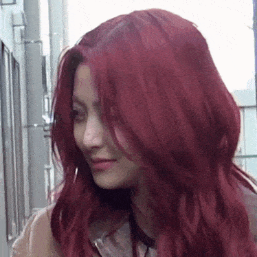 a woman with red hair is standing in a hallway and smiling .