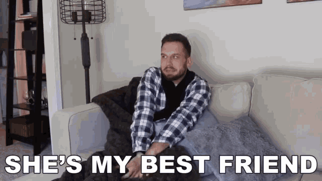 a man is sitting on a couch with the words she 's my best friend written below him .
