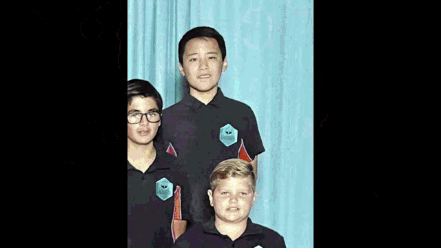 a group of boys are posing for a picture and one of them has the letter v on their shirt