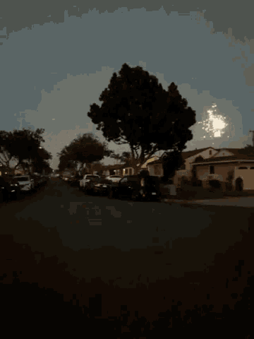 fireworks are displayed over a residential street