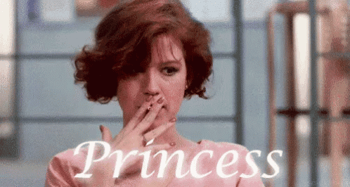 a woman with red hair is covering her mouth with her hand in front of the word princess
