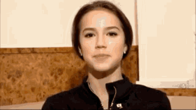 a close up of a woman 's face with a wooden background .
