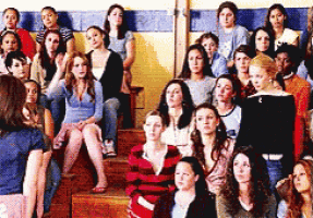 a large group of women are sitting on the steps of a school building