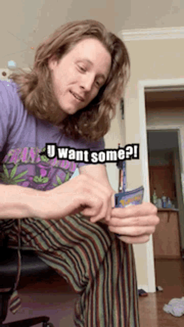 a man with long hair wearing a purple shirt that says " u want some "