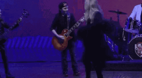 a man playing a guitar and a woman singing on a stage