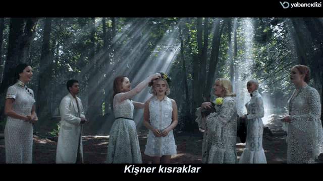 a group of women in white dresses are standing in the woods with the words kisner kisraklar on the bottom