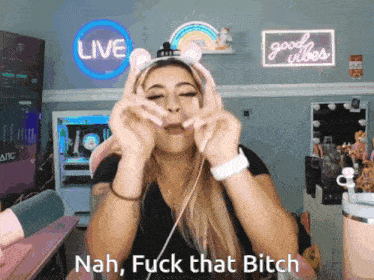 a woman wearing headphones says nah fuck that bitch in front of a neon sign that says good vibes