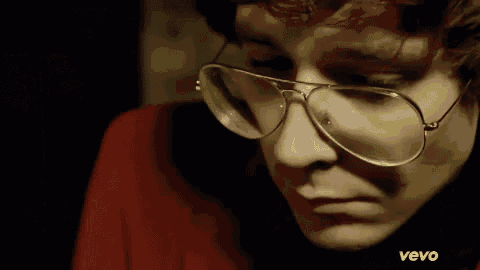 a close up of a person wearing glasses and a vevo logo