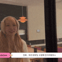 a woman wearing ear muffs is smiling in front of a sign that says jsom