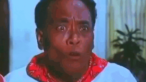 a man is wearing a red bandana and a white shirt and making a surprised face .