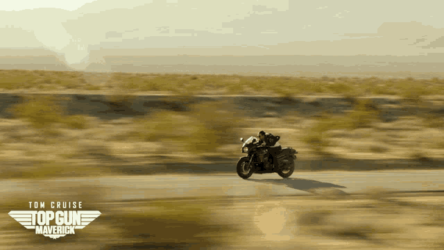 a poster for top gun maverick shows a man riding a motorcycle on a desert road