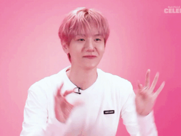 a man with pink hair is wearing a white shirt that says buzzfeed celeb on the bottom