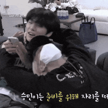 a man with a bandage on his head holds a cell phone next to another man with a bandage on his face