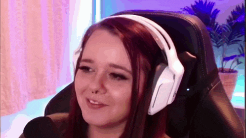 a woman wearing headphones is sitting in a chair .