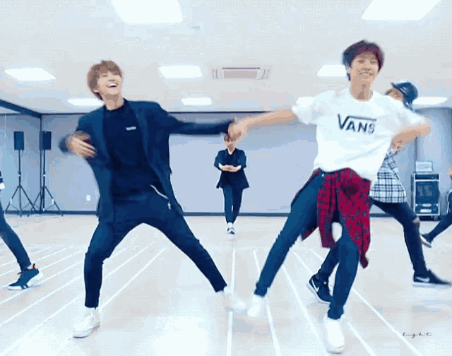 a man wearing a white vans shirt is dancing