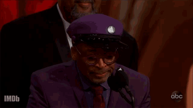 a man wearing a purple hat and glasses says let 's do the right thing