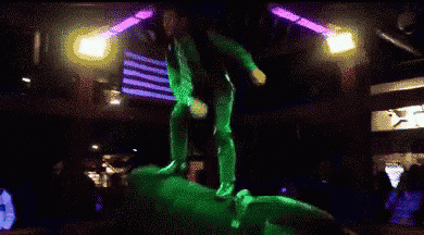 a man in a tie stands on top of a statue in a dark room