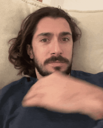 a man with long hair and a beard is laying down
