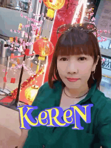 a woman taking a selfie in front of a sign that says keren on it