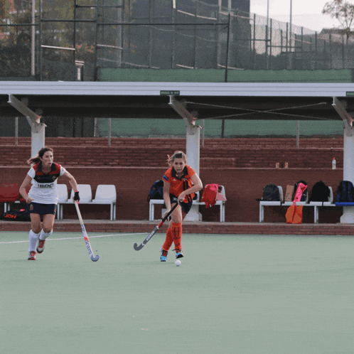 a field hockey player wearing a white shirt that says imdc on the front
