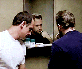 two men are looking at their reflections in a bathroom mirror