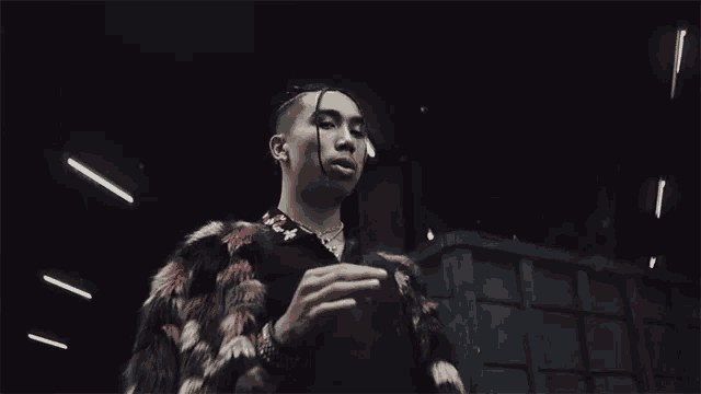 a man in a fur coat smoking a cigarette in a dark room