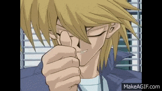 a close up of a man 's face with his eyes closed and his fist in his mouth .