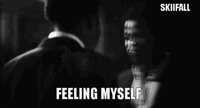 a black and white photo of a man looking at himself in a mirror with the words feeling myself above him .