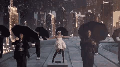 a woman in a white dress is surrounded by people holding umbrellas
