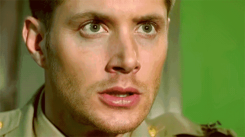 a close up of a man 's face with a green background behind him
