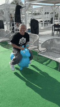 a man in a black shirt is riding a blue toy