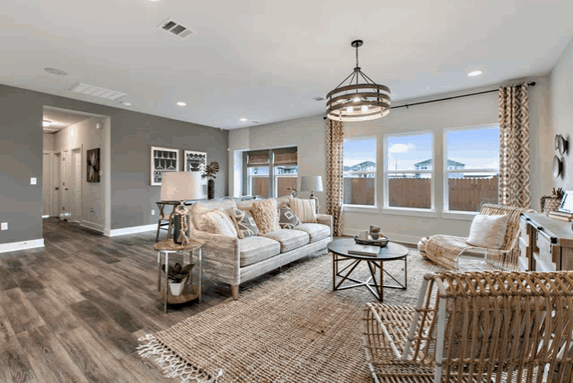 a living room with a couch and wicker chairs and a chandelier