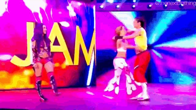 a couple of women are dancing on a stage in front of a sign that says jam .