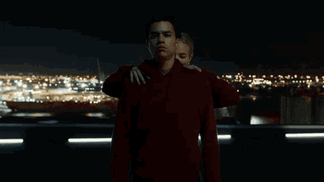 a man in a red shirt is being held by a woman in a red shirt