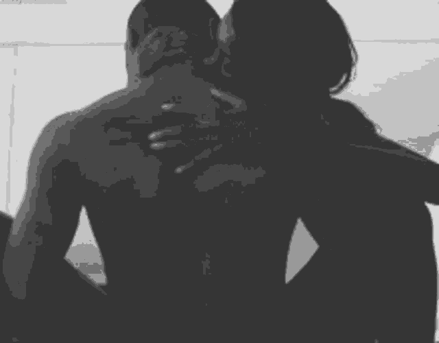a black and white photo of a man and woman kissing