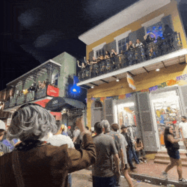 a crowd of people are gathered outside a building with the number 530 on the side