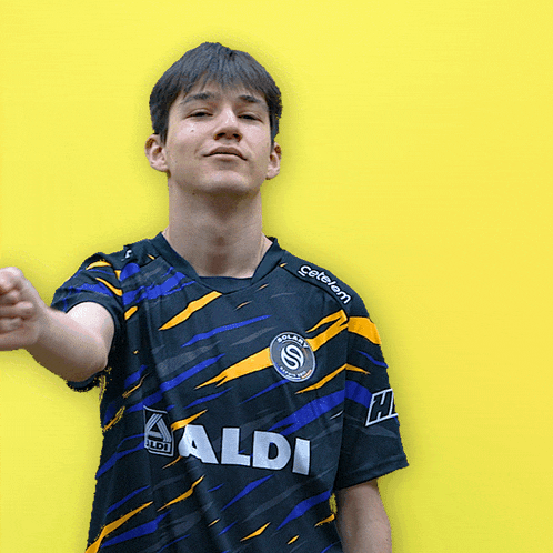 a young man wearing a black and yellow shirt that says aldi