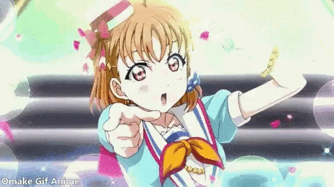 a girl in a blue dress is pointing at the camera with a surprised look on her face .