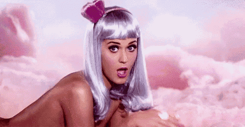 a naked woman in a wig is laying on her stomach in a cloud .