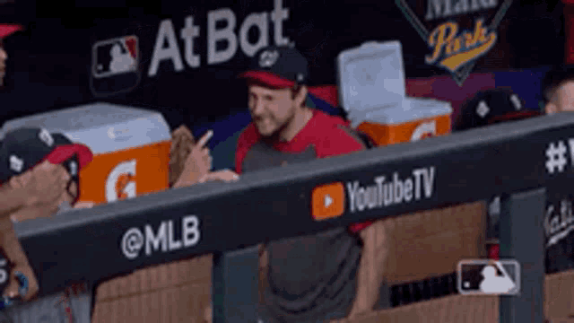 a man sitting in a dugout with a youtube tv banner