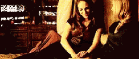 two women are sitting on the floor holding hands and smiling