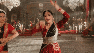 a woman in a red and silver dress is dancing