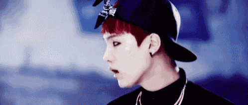 a close up of a person wearing a hat and a bandana .