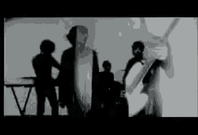 a black and white photo of a group of people standing next to each other in a room .